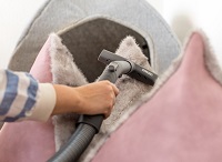 Cleaning cat tree with pet hair upholstery nozzle